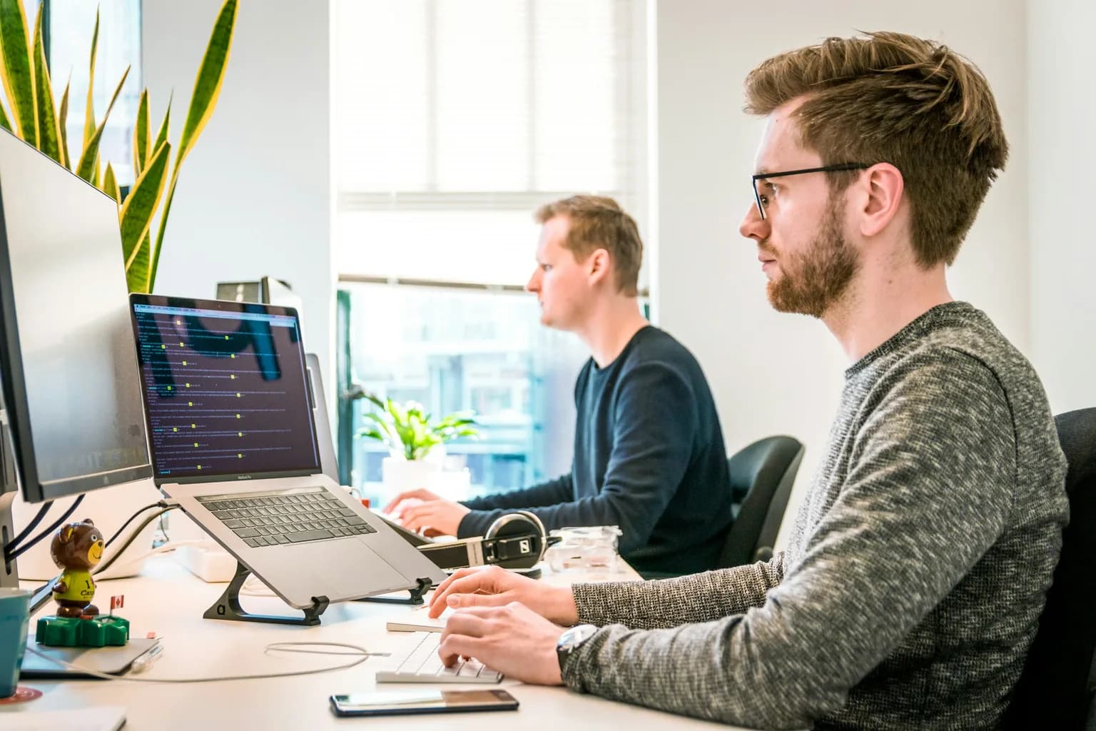 Twee mensen aan systemen die naast elkaar draaien
